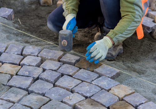 Sound of workers hammering granite stones into place echoed through streets as they paved pavement with industrial cobblestones